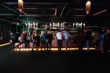 People socializing at a modern bar with premium drinks and stylish lighting