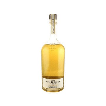 Bottle of Código 1530 Reposado tequila with golden amber liquid and beige label