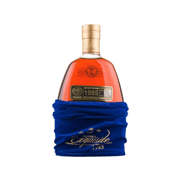 Bottle of Oliver's Capusillo 1985 premium Dominican rum partially wrapped in blue velvet pouch